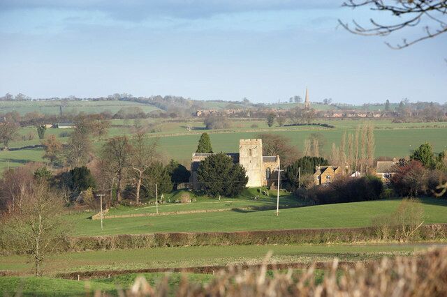 Barford St Michael parish church viewed from the Nether Worton Road, with the village of Bloxham and the spire of St Mary's parish church in the distance.