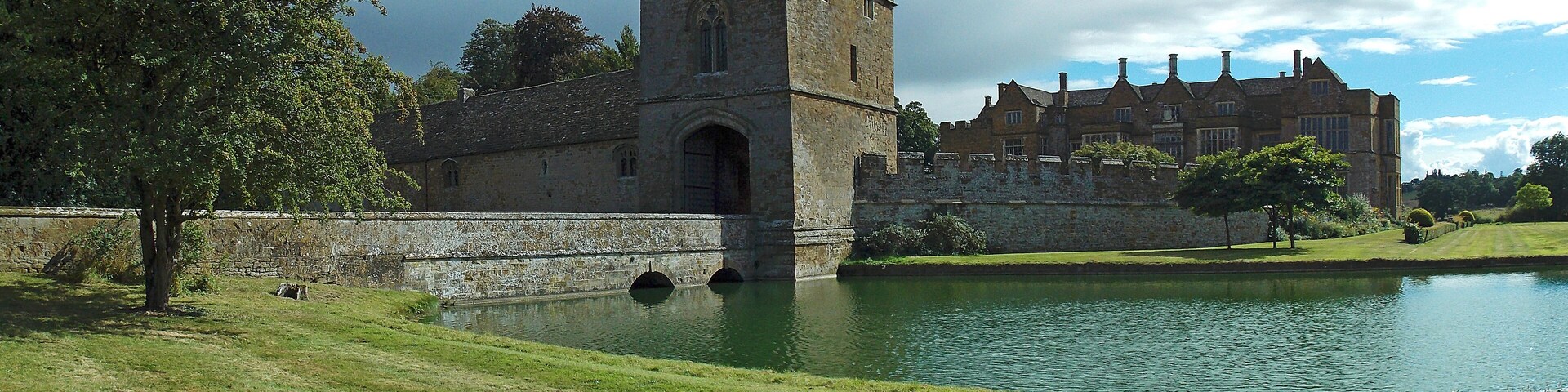 Broughton Castle, Oxfordshire: the gatehouse, the access bridge over the moat, with the main bilding in the background