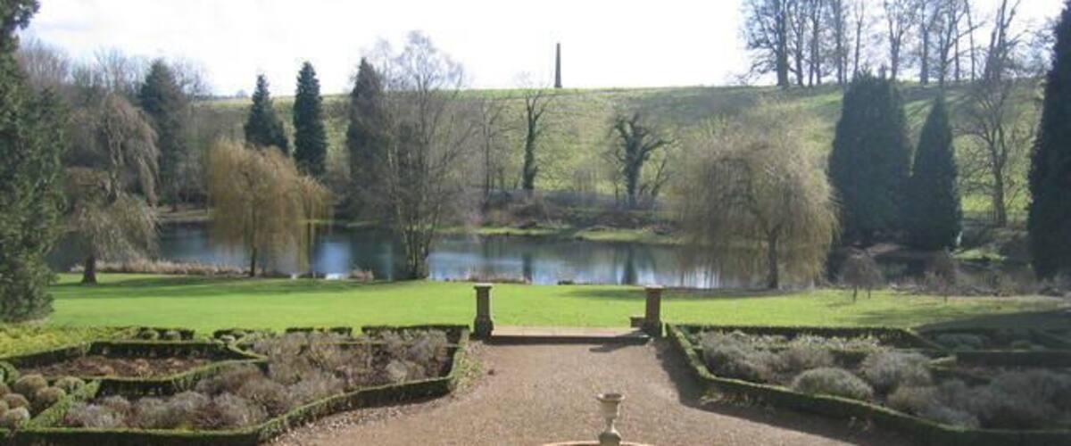 Wroxton Abbey grounds. The gardens of 553107, looking the other way from 553109. In the middle years of the eighteenth century Lancelot Brown remodelled the gardens making use woodland and water in his characteristic personal style. The classic features included a lawn sweeping up to the house, clumps of trees, a serpentine lake and an encircling tree belt and carriage drive, also showing a serpentine geometry. This is the style of what is often known as the 'English landscape garden', or possibly even the 'Brownian' style.