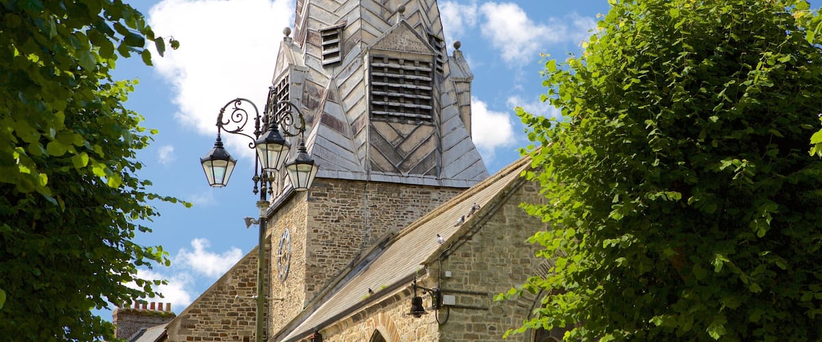 Une église dotée d’un clocher haut et effilé, surmonté d’une horloge.