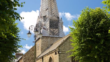 Uma igreja com uma torre alta e um campanário pontudo, com um relógio.