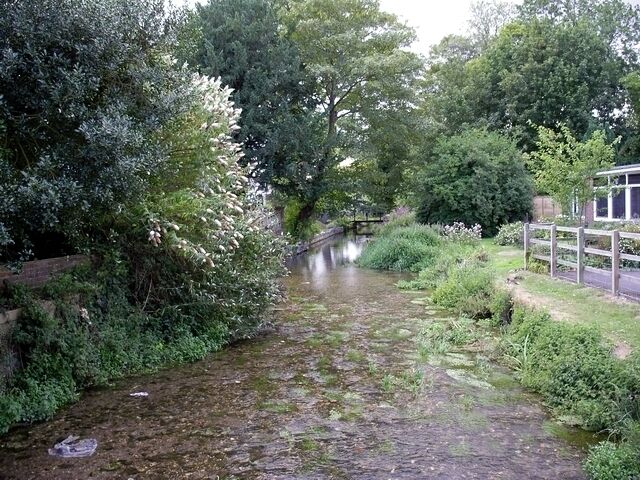 River Test, Overton. A young River test flows west after passing under a mill and Kingsclere Road.