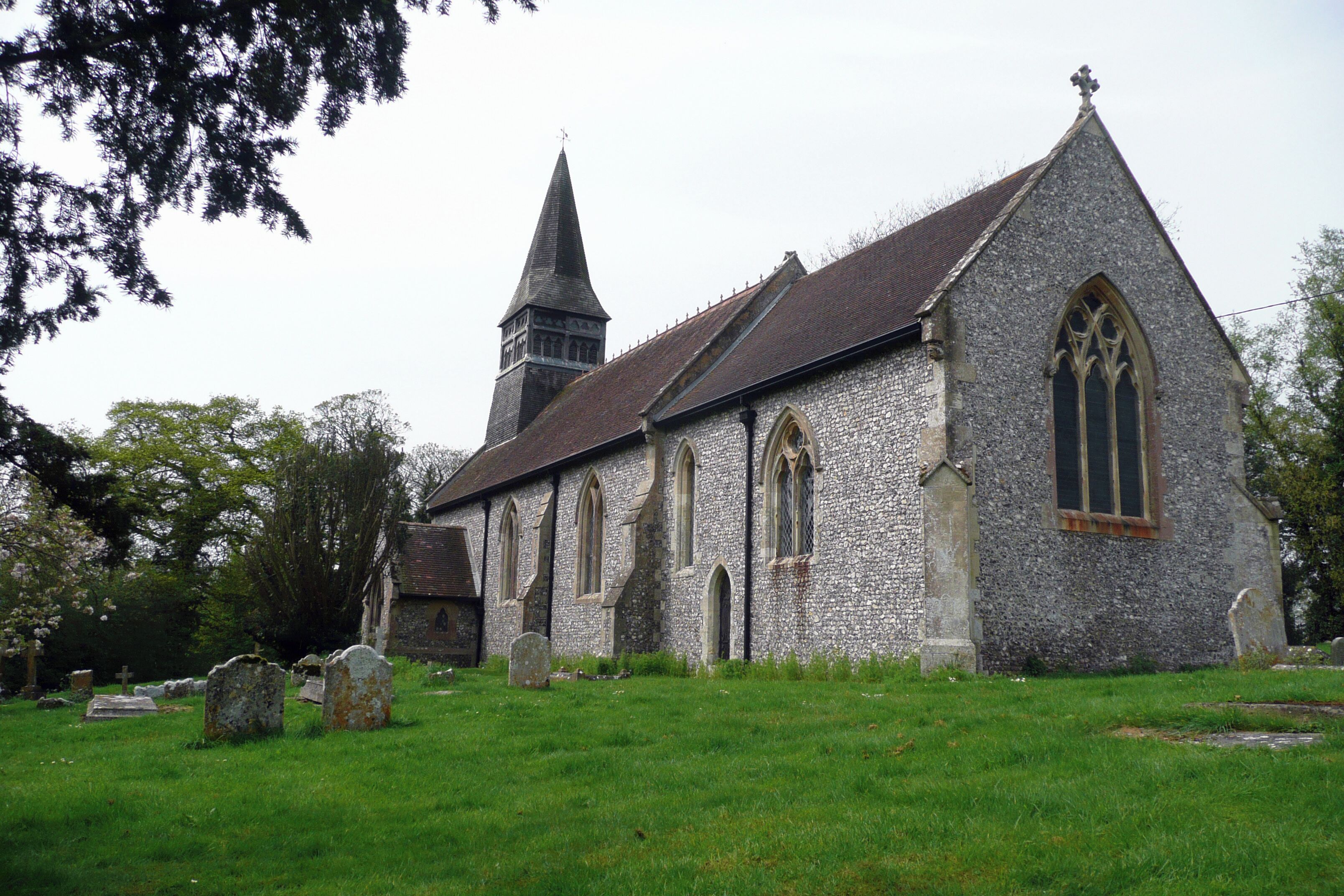 A church with a tall steeple and a stone building with arched windows.