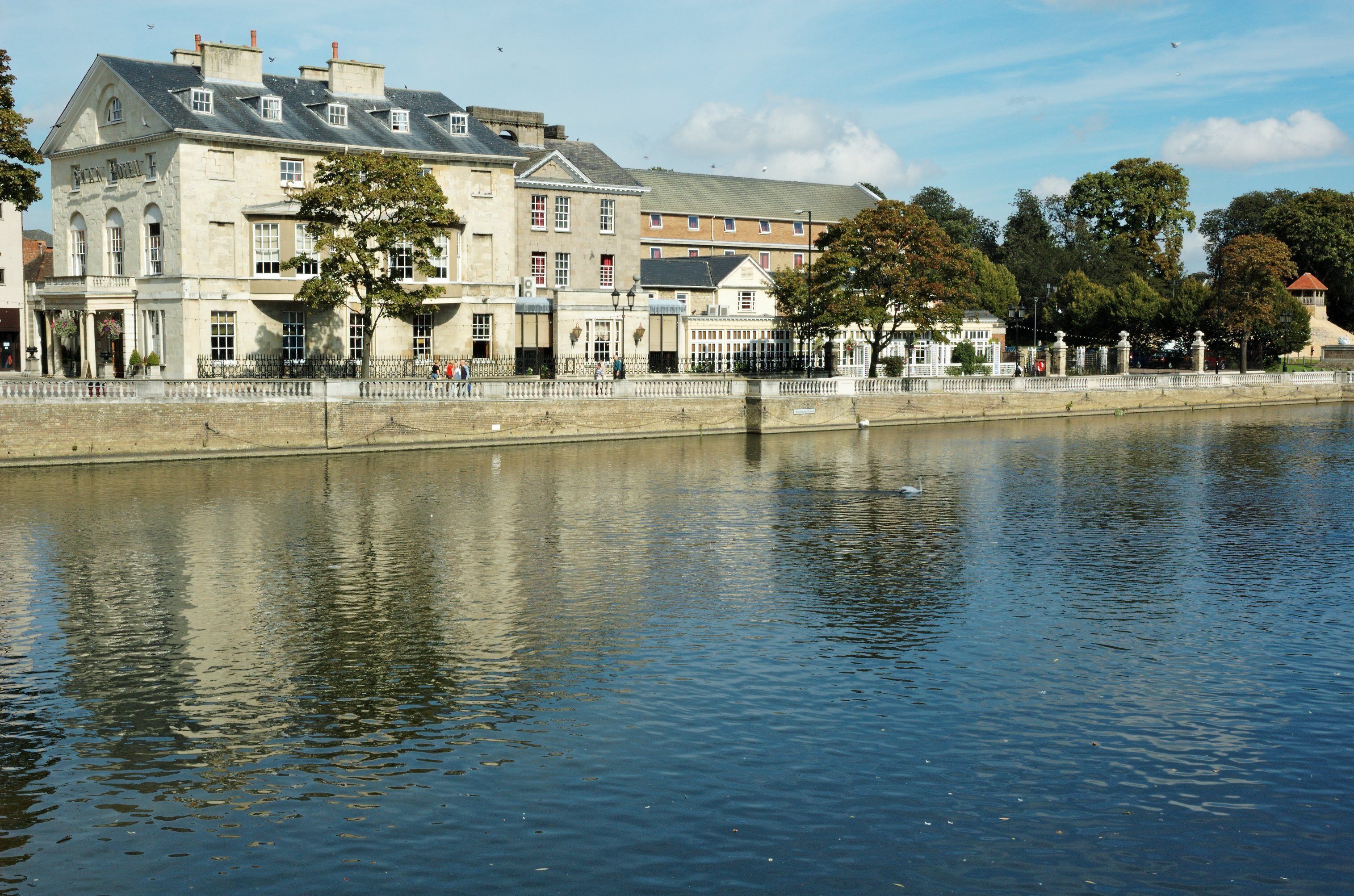 A riverside view with a historic building and trees.