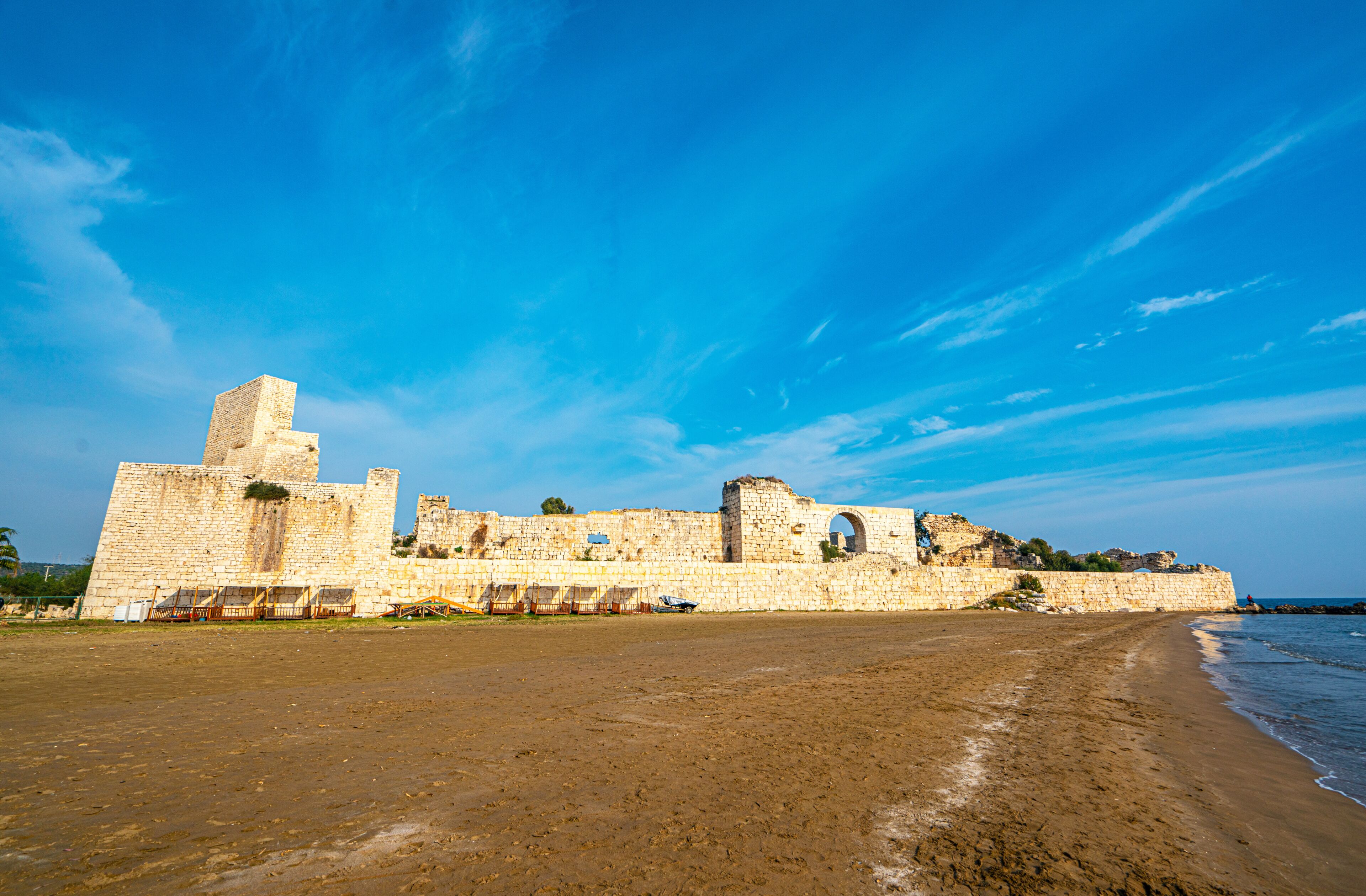 Un sitio histórico costero con antiguas murallas y ruinas de piedra.