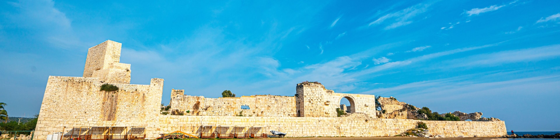 A coastal historical site with ancient stone walls and ruins.
