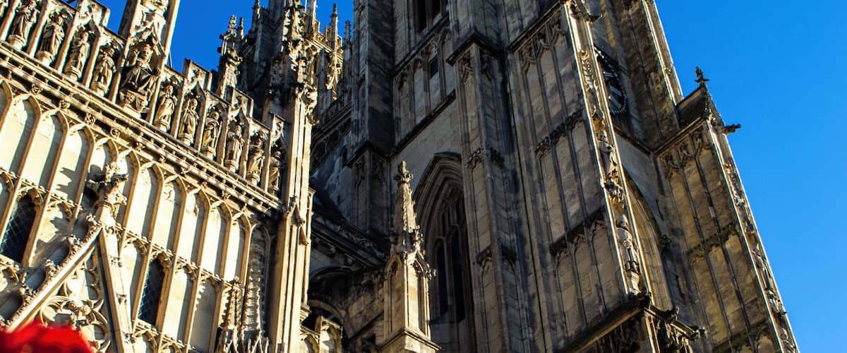 A Gothic cathedral with intricate stonework and a statue in front.