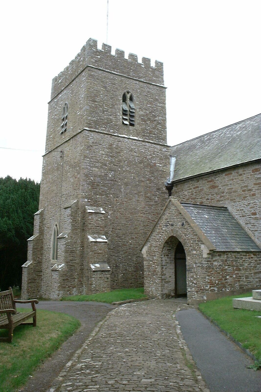 A stone church with a tall tower and arched entrance.