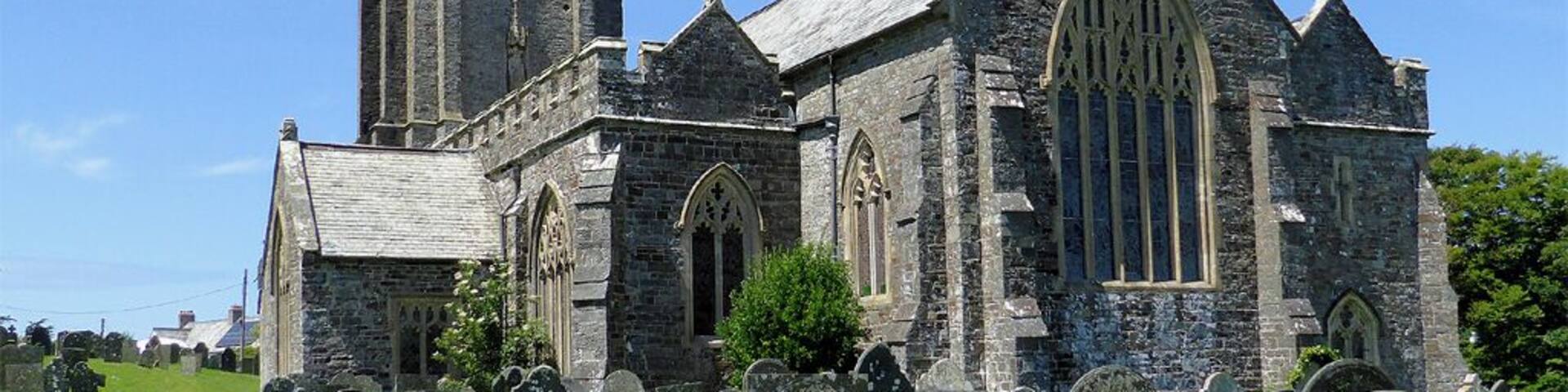 A historic church with a tall tower and Gothic architecture, surrounded by a cemetery.