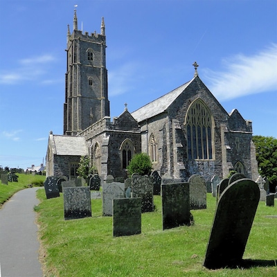 Une église historique, dotée d’un haut clocher et d’une architecture gothique, entourée d’un cimetière.