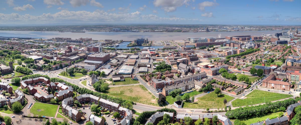 An aerial view of a city with a river, industrial buildings, and residential areas.