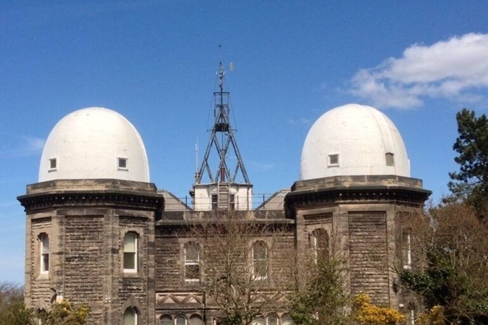 A large, historic building with two prominent domes and a tall tower.