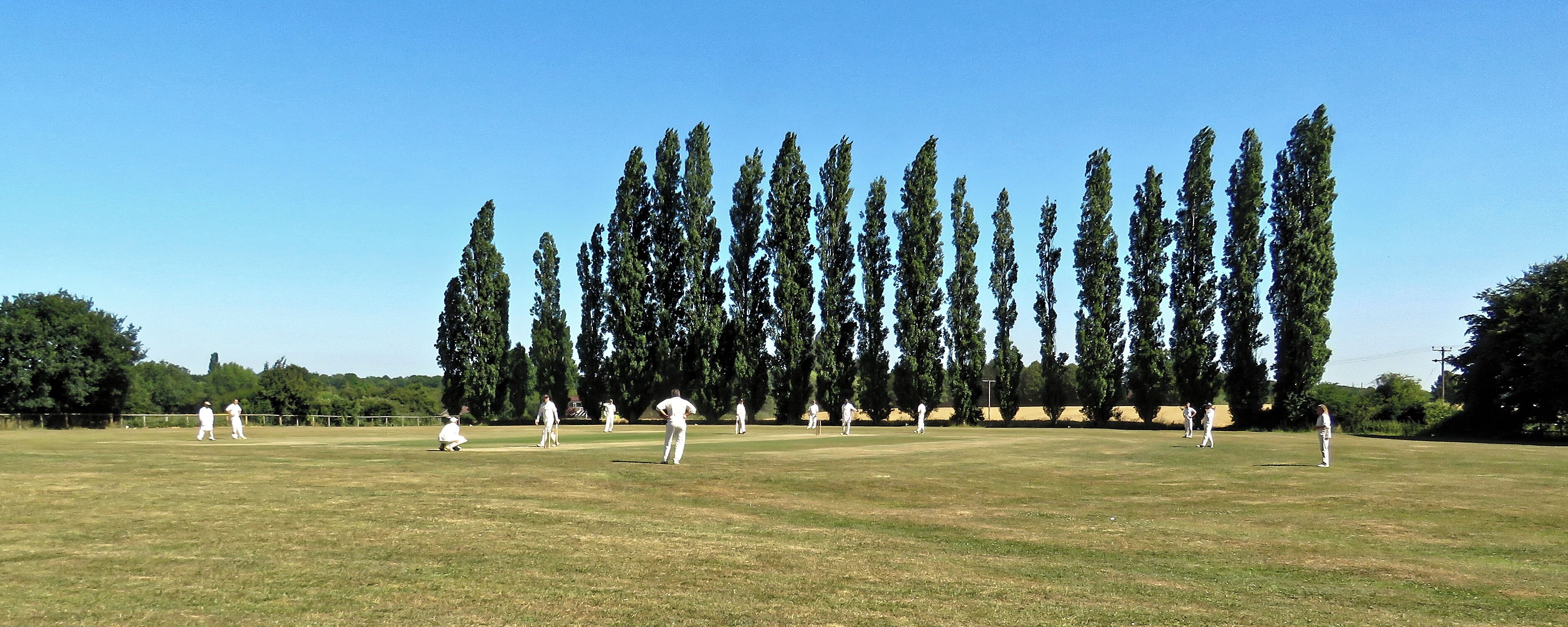 A public Herts and Essex League Saturday cricket game between Little Hallingbury CC and Thorley CC (Little Hallingbury batting), at Gaston Green, Little Hallingbury, Essex, England in 2018. Camera: Canon PowerShot SX60 HS Software: File lens-corrected, optimized, perhaps cropped, with DxO PhotoLab, and likely further optimized with Adobe Photoshop CS2.