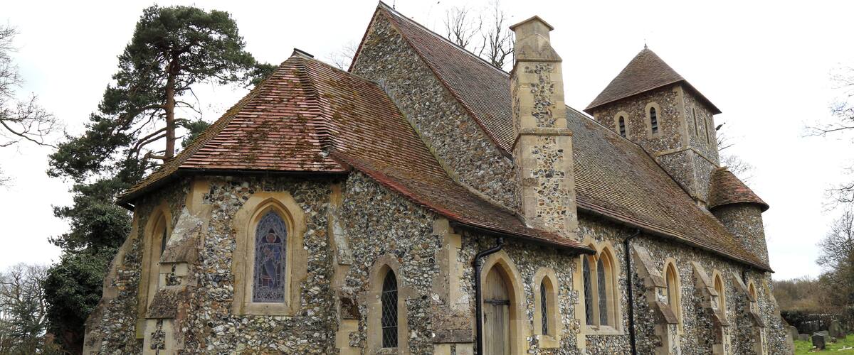 A historic stone church with arched windows and a steeply pitched roof.