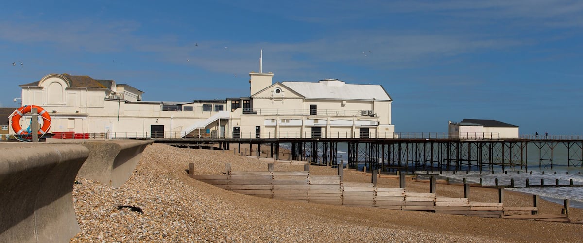 A coastal building with a pier extending into the sea.