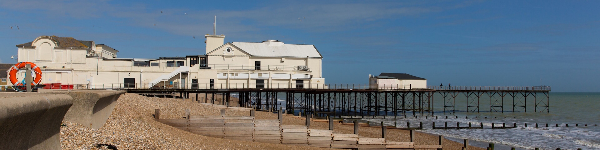 A coastal building with a pier extending into the sea.
