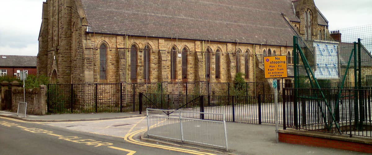 A historic church with a large arched window and a pointed roof.