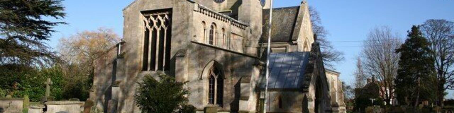 St Swithin's parish church, Bicker, Lincolnshire, seen from the southwest, showing the truncated end of the Norman nave. The nave originally extended further west but now endw with a square-headed window with rectilinear tracery.