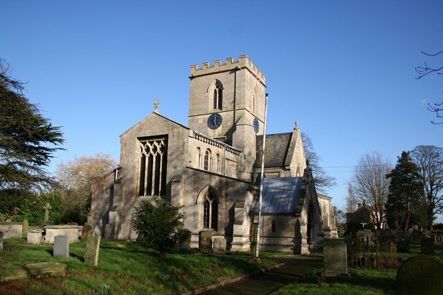 A historic church with a clock tower, surrounded by a cemetery.