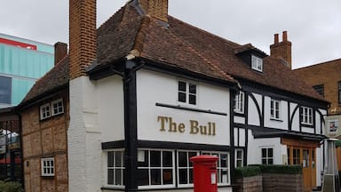 Um pub tradicional chamado "The Bull" com uma caixa de correio vermelha em frente.