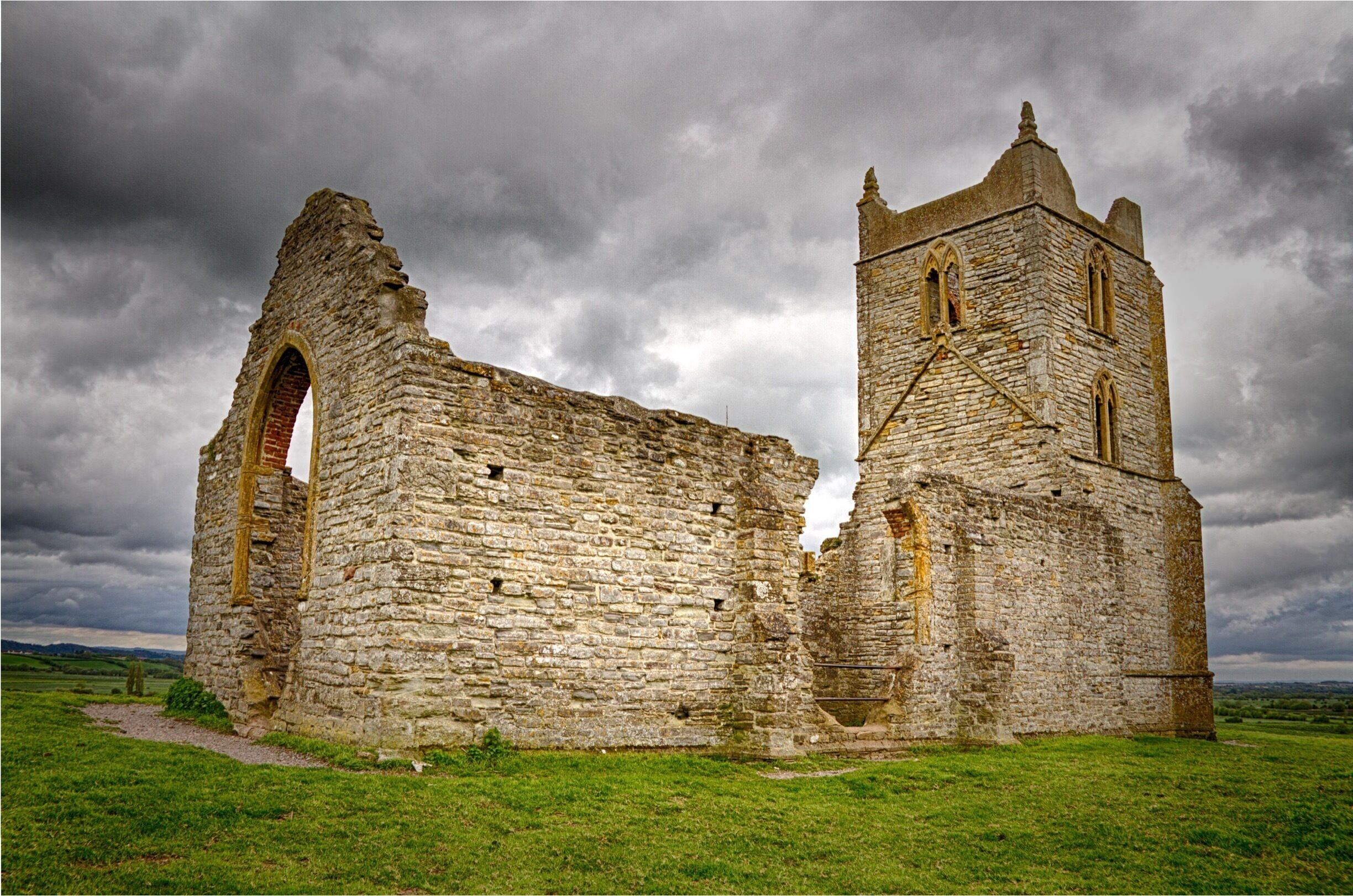 Burrow Mump is a hill and historic site overlooking Southlake Moor in the village of Burrowbridge within the English county of Somerset. It is a scheduled monument, with the ruined church on top of the hill a Grade II listed building. Wikipedia