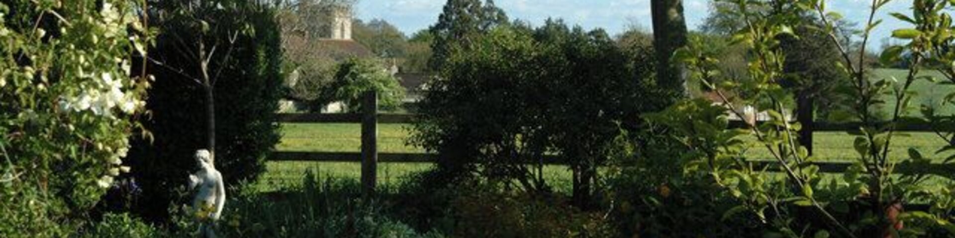 Cossington church seen from a village garden A view of the church taken from a cottage garden across pasture land in what was once Cossington Park belonging to the manor.