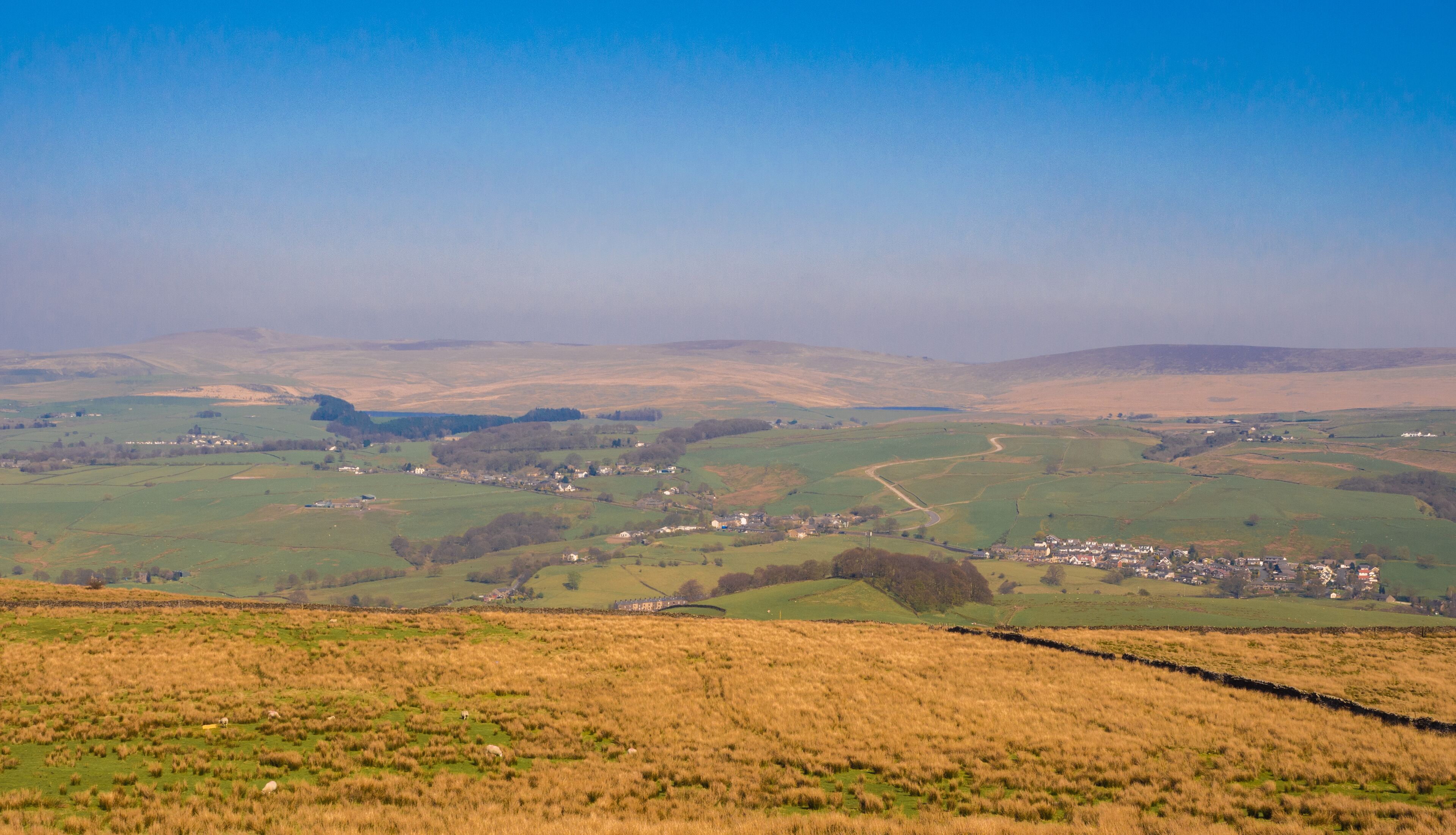 Rolling hills, a small village, and a stone wall.