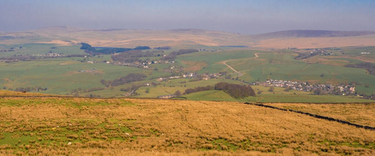 Rolling hills, a small village, and a stone wall.