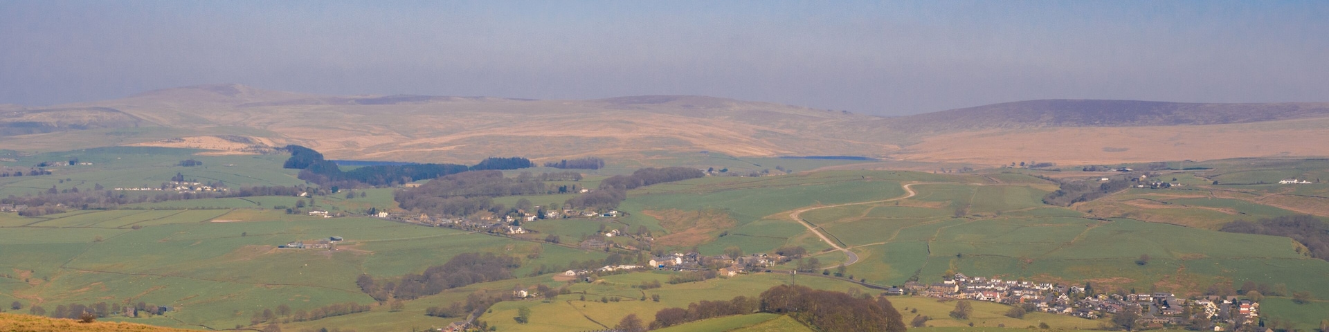 Rolling hills, a small village, and a stone wall.