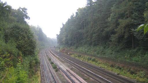 Railway line between Farnborough and Brookwood Viewed looking in the "up" direction towards London, from the aqueduct that takes the Basingstoke Canal over the railway, the main London to Southampton railway line passes through a cutting here between Farnborough and Brookwood stations.
