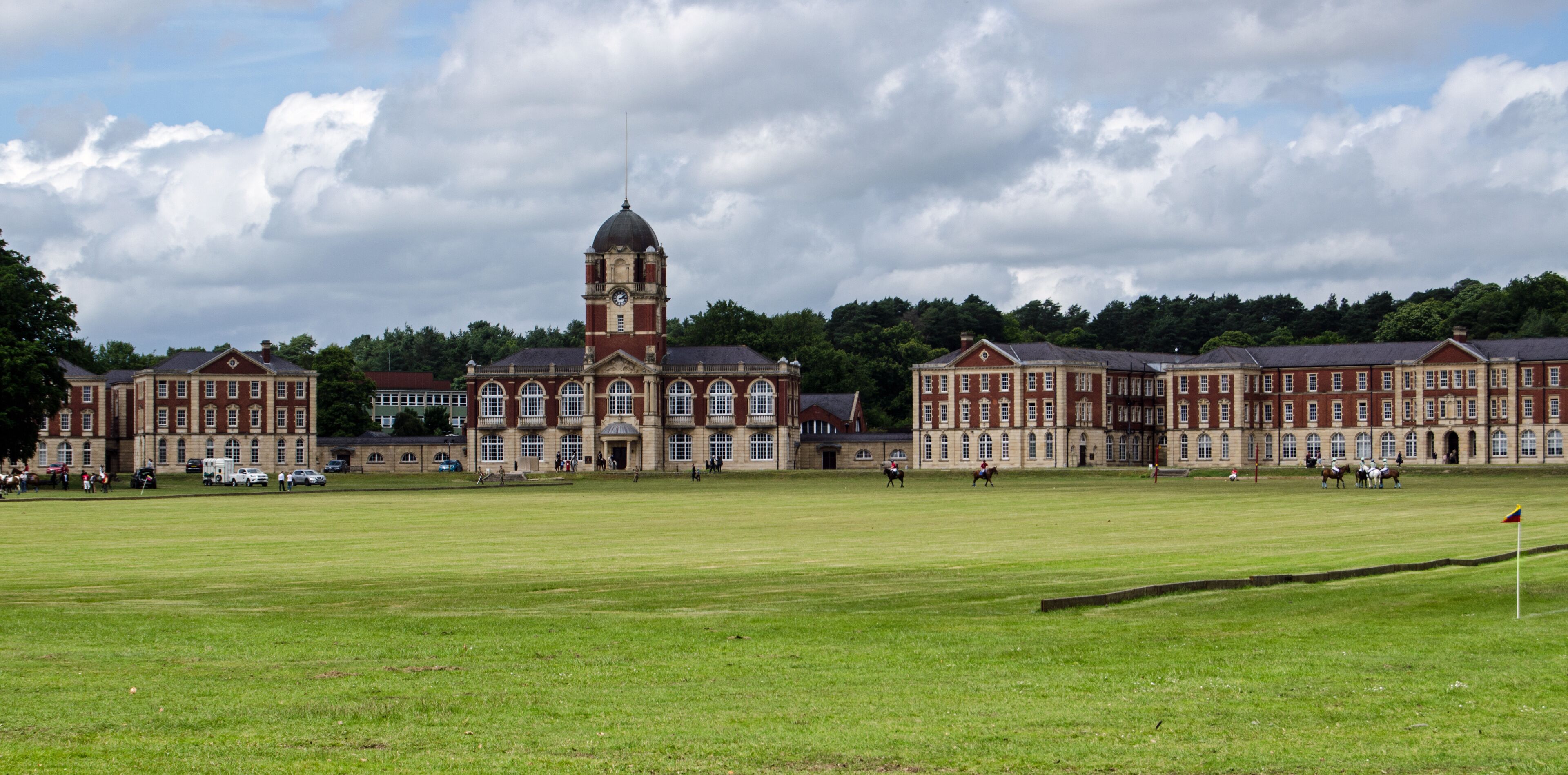 A large, historic building with a prominent tower and multiple red-brick structures.