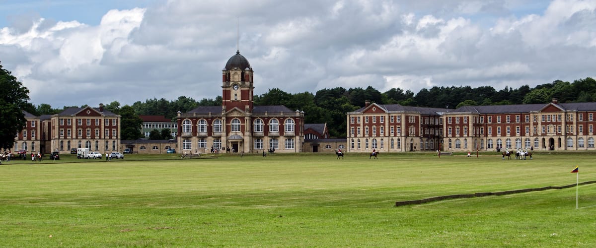 A large, historic building with a prominent tower and multiple red-brick structures.
