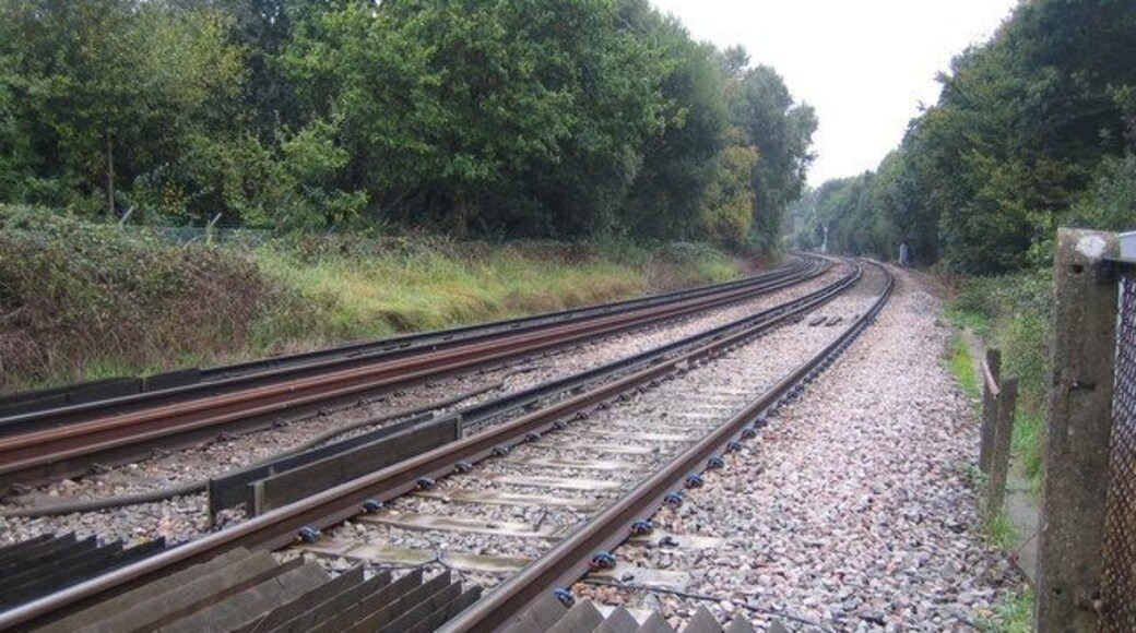 Frimley Junction Once upon a time this was a junction with lines diverging away to the east and west. Nowadays it is just the straight line between Ash Vale and Ascot stations. This view was taken from the pedestrian crossing at the end of The Hatches road, looking in the direction of Frimley station. The standard 750 volt DC offset third rail of the former Southern Railway electric system is clearly visible.