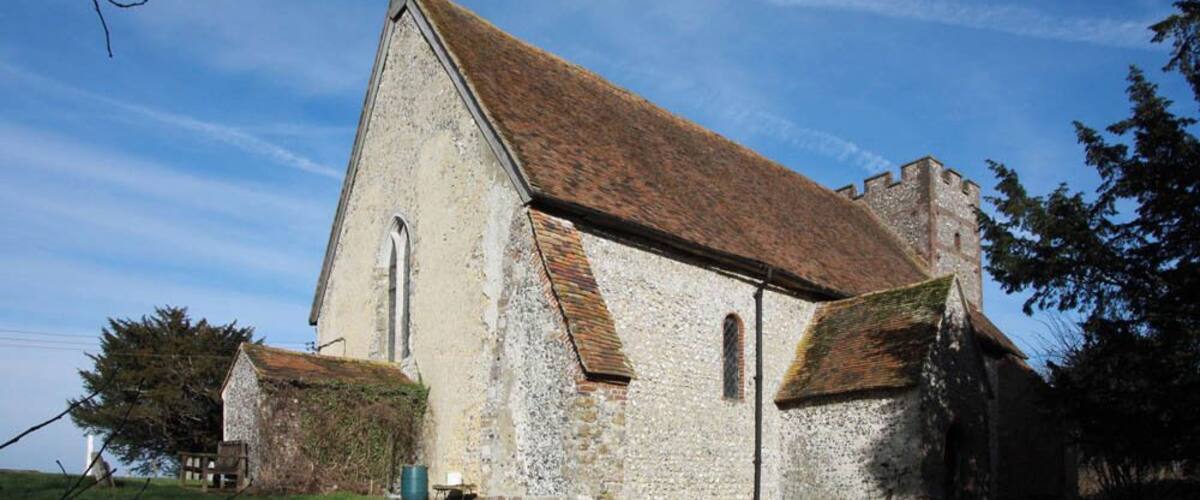 An old stone church with a steep roof and a small bell tower.