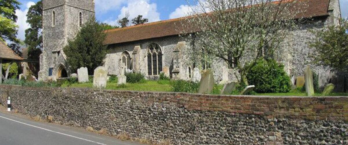 A historic church with a tower and a stone wall.