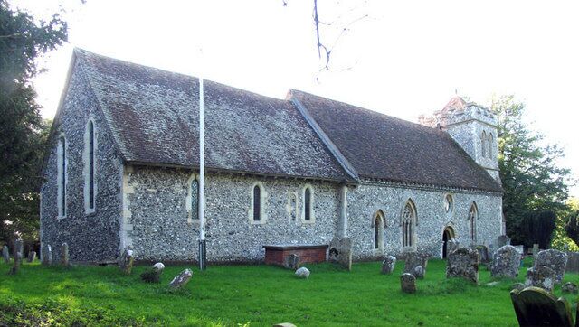 A stone church with a steeple, surrounded by a cemetery with headstones.