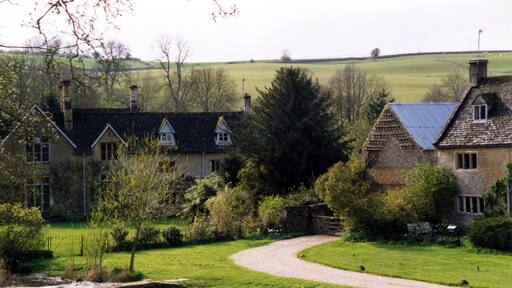 The Waysend and River Eye from the ford at Upper Slaughter. The Waysend (left to centre) is a 17th century house remodelled mid 19th century and Grade II Listed. The foot footbridge is similarly Grade II Listed probably also mid 17th century. Lower Farmhouse (right) also Grade II Listed 17th century farmhouse extended around 1700.