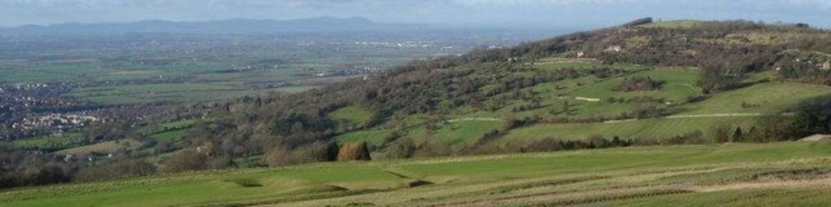 Nottingham Hill viewed from Cleeve Hill Beyond Nottingham Hill is the Severn Valley with the line of the Malvern Hills on the horizon.