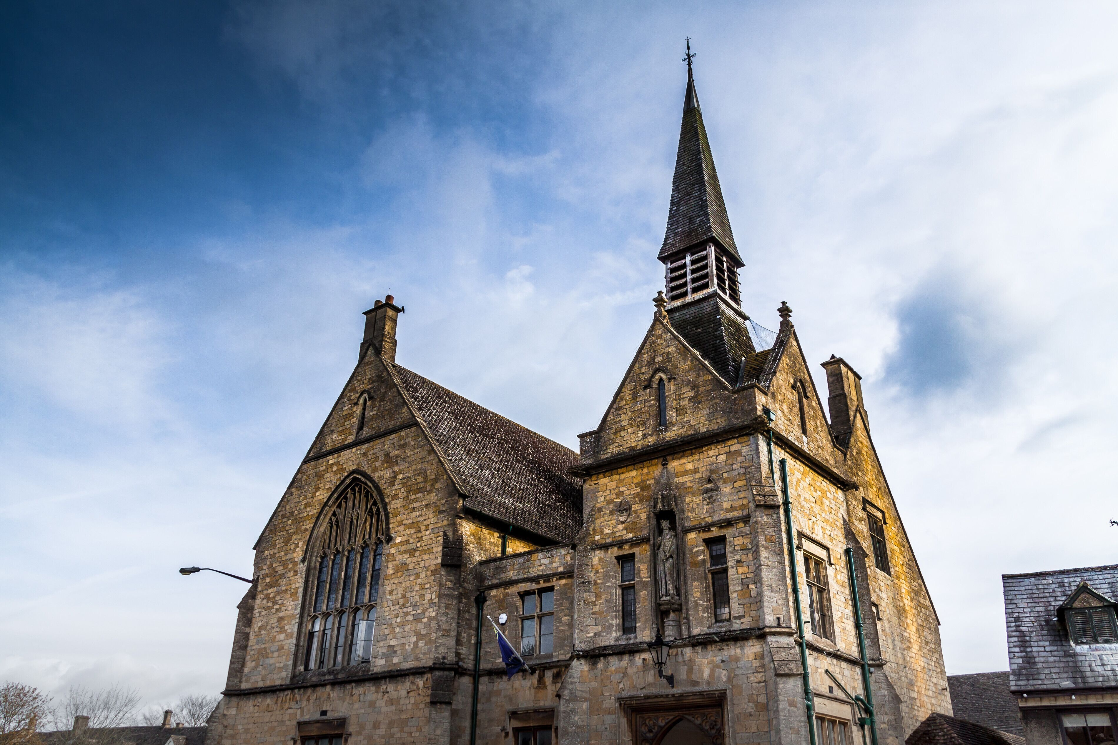 A historic church with a tall steeple and large arched windows.