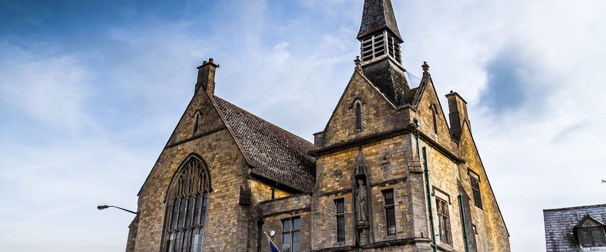 A historic church with a tall steeple and large arched windows.