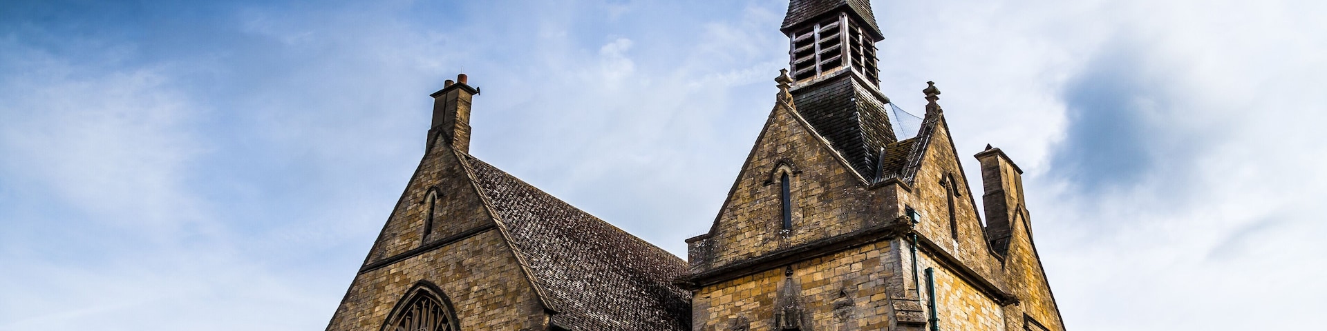 A historic church with a tall steeple and large arched windows.