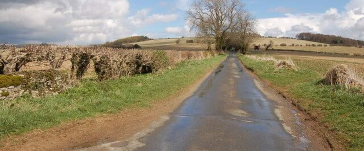 Cotswold lane near Charlton Abbots View looks eastwards as this unclassified road climbs upwards towards Roel Gate.