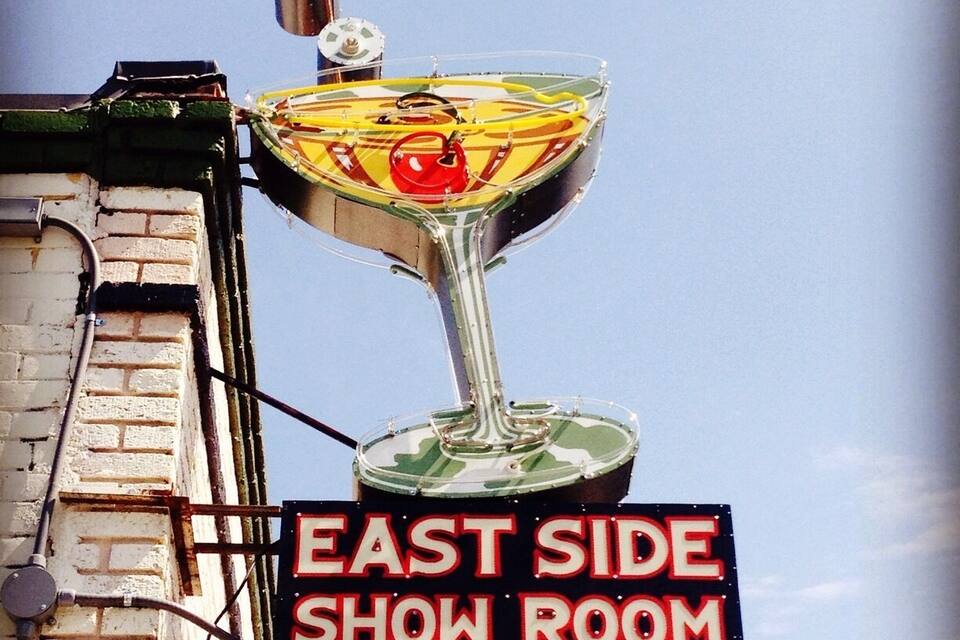 Un insegna luminosa al neon per l'East Side Show Room con un bicchiere da margarita.