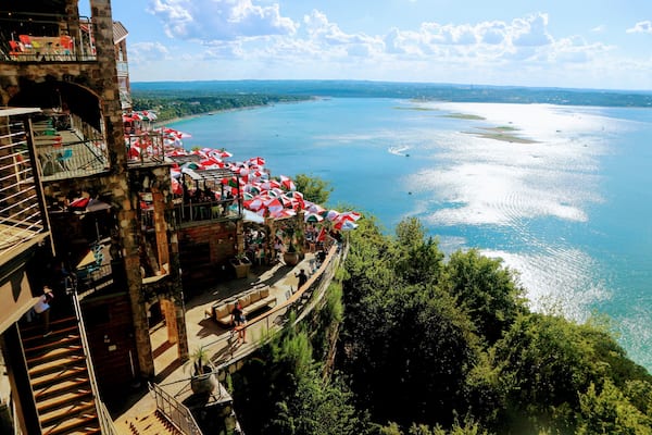 Un restaurant situé au bord de l’eau, avec une terrasse offrant une vue sur une vaste étendue d’eau.