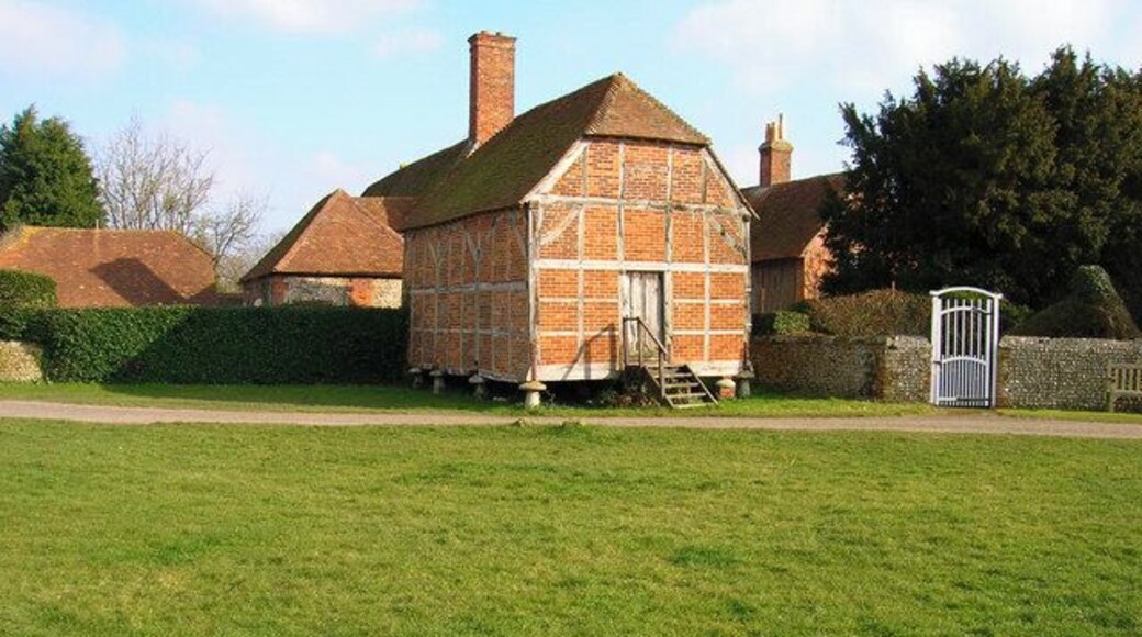 Old granary, Eastergate. Part of Eastergate Manor, part of which can be seen behind, it was built on staddle stones around the 17th century. Eastergate church is to the right, part of whose flint wall can be seen.