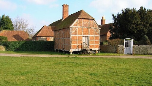 Old granary, Eastergate. Part of Eastergate Manor, part of which can be seen behind, it was built on staddle stones around the 17th century. Eastergate church is to the right, part of whose flint wall can be seen.
