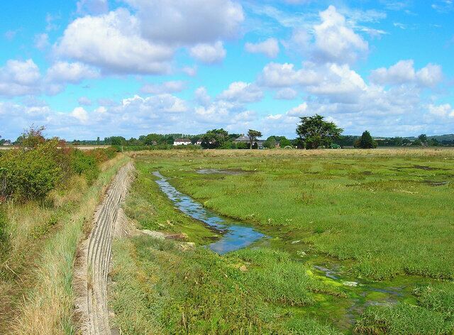 Embankment, Chidham Creek. Sea wall built to prevent floods. The creek heads under the road to the pond the other side.