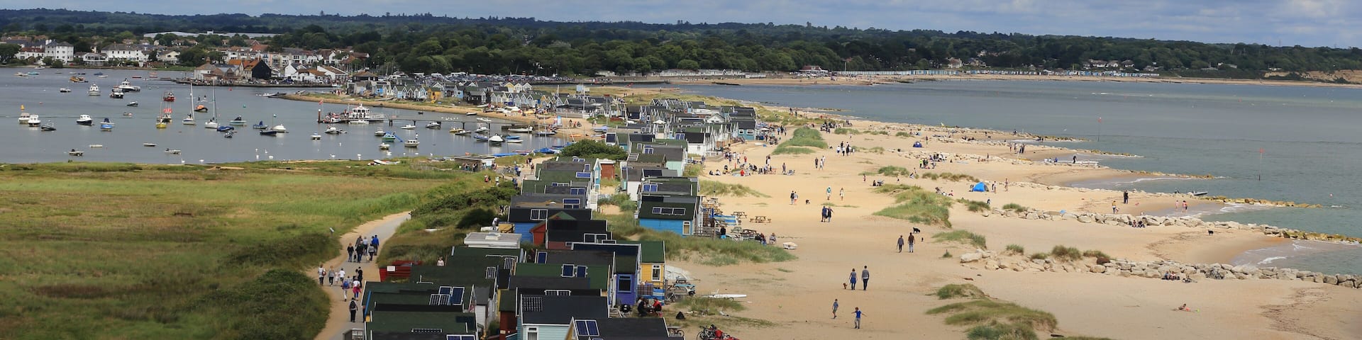 The beach and beach huts at Hengistbury Head, Christchurch Harbour, Dorset, England, UK.