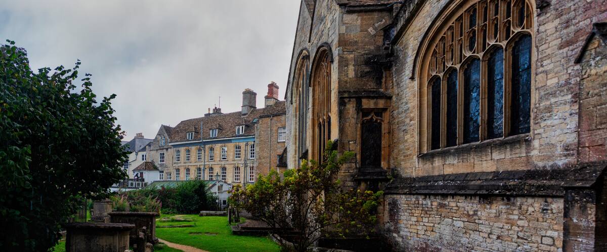 A historic building with arched windows and a well-maintained lawn.