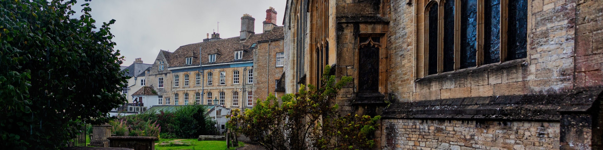 A historic building with arched windows and a well-maintained lawn.